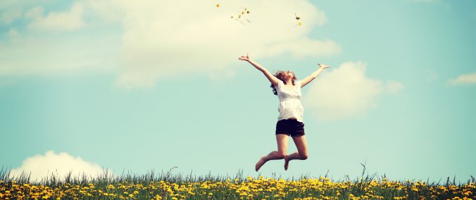 Woman Jumping in Flower Field_wide